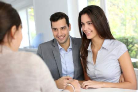 Real Estate Agent talking to a couple buying a home