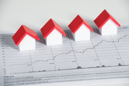 real estate market concept with toy houses on a graph