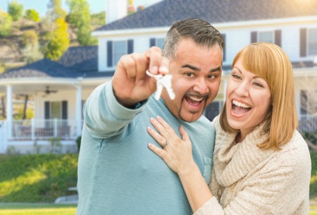 smiling man and woman holding house keys