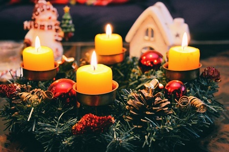 four candles on top of a christmas wreath